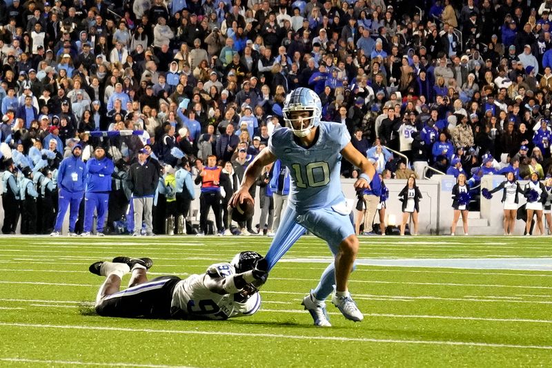 Nov 11, 2023; Chapel Hill, North Carolina, USA; North Carolina Tar Heels quarterback Drake Maye (10) looks to pass as Duke Blue Devils defensive end Wesley Williams (97) defends in the second quarter at Kenan Memorial Stadium. Mandatory Credit: Bob Donnan-USA TODAY Sports