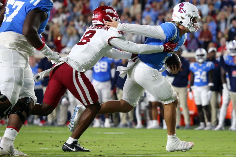 Oct 7, 2023; Oxford, Mississippi, USA; Mississippi Rebels quarterback Jaxson Dart (2) runs with the ball as Arkansas Razorbacks defensive back Jayden Johnson (8) attempts to make the tackle during the first quarter at Vaught-Hemingway Stadium. Mandatory Credit: Petre Thomas-USA TODAY Sports