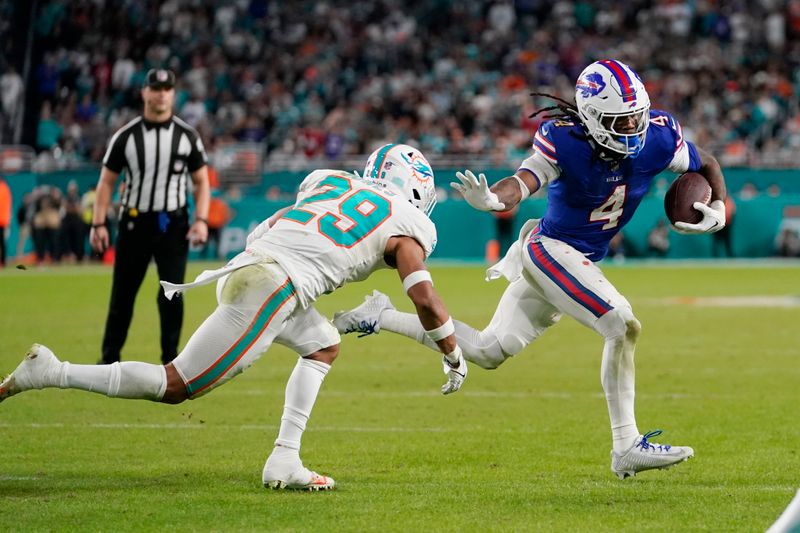 Buffalo Bills running back James Cook (4) runs with the football as Miami Dolphins safety Brandon Jones (29) defends during the second half of an NFL football game, Sunday, Jan. 7, 2024, in Miami Gardens, Fla. (AP Photo/Lynne Sladky)