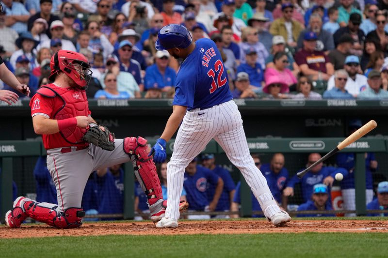 Mar 6, 2024; Mesa, Arizona, USA; Chicago Cubs first baseman Dom Smith (12) reacts after getting hit with a pitch against the Los Angeles Angels in the second inning at Sloan Park. Mandatory Credit: Rick Scuteri-USA TODAY Sports