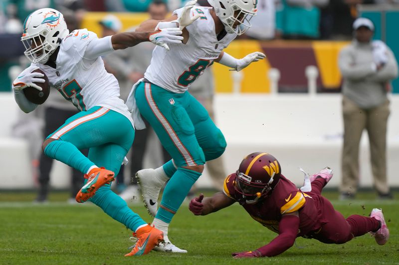 Miami Dolphins wide receiver Jaylen Waddle (17) runs past Washington Commanders cornerback Danny Johnson during the first half of an NFL football game Sunday, Dec. 3, 2023, in Landover, Md. (AP Photo/Mark Schiefelbein)