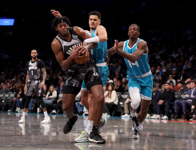 NEW YORK, NEW YORK - FEBRUARY 10: Day'Ron Sharpe #20 of the Brooklyn Nets heads for the net as Josh Green #10 and Moussa Diabate #14 of the Charlotte Hornets defend in the first half at Barclays Center on February 10, 2025 in the Brooklyn borough of New York City. NOTE TO USER: User expressly acknowledges and agrees that, by downloading and or using this photograph, User is consenting to the terms and conditions of the Getty Images License Agreement. (Photo by Elsa/Getty Images)