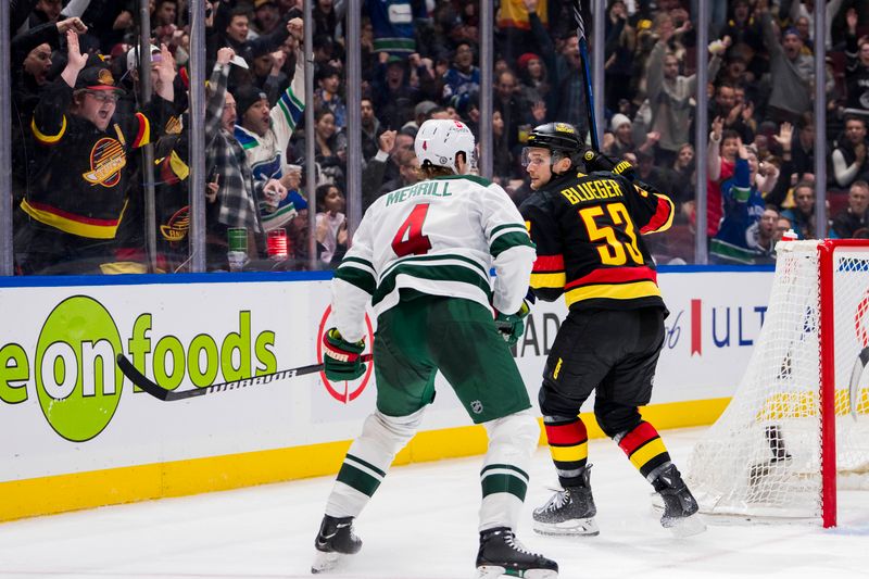 Dec 7, 2023; Vancouver, British Columbia, CAN; Minnesota Wild defenseman Jon Merrill (4) watches as Vancouver Canucks forward Teddy Blueger (53) celebrates his goal in the third period at Rogers Arena. Vancouver won 2-0.  Mandatory Credit: Bob Frid-USA TODAY Sports