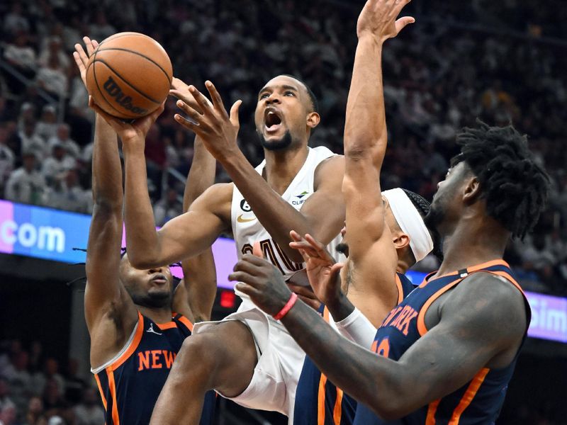 CLEVELAND, OHIO - APRIL 15: Evan Mobley #4 of the Cleveland Cavaliers shoots over Josh Hart #3 and Julius Randle #30 of the New York Knicks during the third quarter of Game One of the Eastern Conference First Round Playoffs at Rocket Mortgage Fieldhouse on April 15, 2023 in Cleveland, Ohio. The Knicks defeated the Cavaliers 101-97. NOTE TO USER: User expressly acknowledges and agrees that, by downloading and or using this photograph, User is consenting to the terms and conditions of the Getty Images License Agreement. (Photo by Jason Miller/Getty Images)