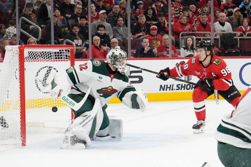Nov 26, 2025; Chicago, Illinois, USA; Chicago Blackhawks center Connor Bedard (98) scores a goal on Minnesota Wild goaltender Filip Gustavsson (32) during the second period at United Center. Mandatory Credit: David Banks-Imagn Images