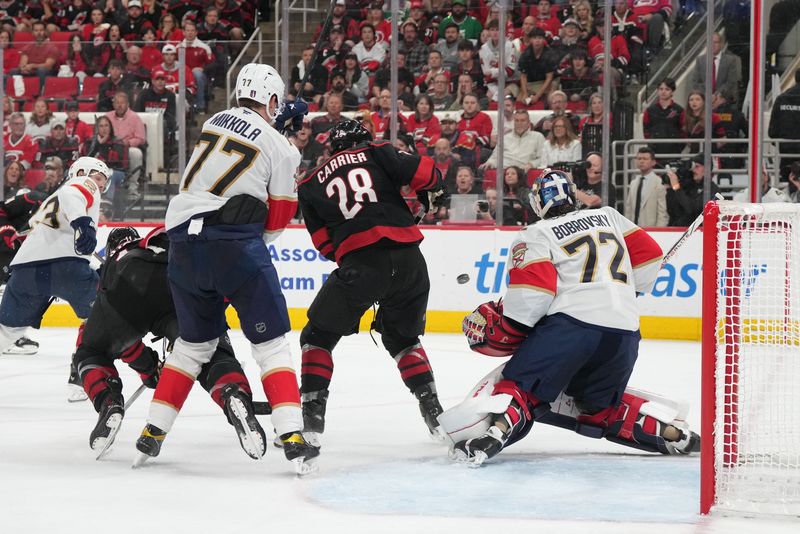 May 20, 2025; Raleigh, North Carolina, USA;  Florida Panthers goaltender Sergei Bobrovsky (72) defends against a shot -as Carolina Hurricanes forward William Carrier (28) screens and is defended by Florida Panthers defenseman Niko Mikkola (77) during the third period in game one of the Eastern Conference Final of the 2025 Stanley Cup Playoffs at Lenovo Center. Mandatory Credit: James Guillory-Imagn Images
