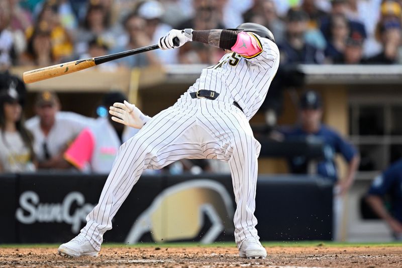 Jul 10, 2024; San Diego, California, USA; San Diego Padres designated hitter Manny Machado (13) falls avoiding an inside pitch during the ninth inning against the Seattle Mariners at Petco Park. Mandatory Credit: Orlando Ramirez-USA TODAY Sports