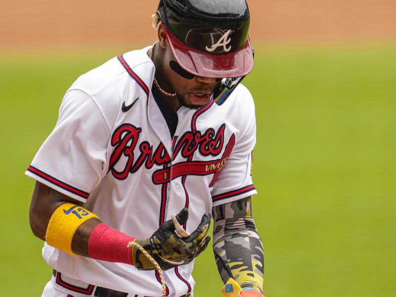 May 21, 2023; Cumberland, Georgia, USA; Atlanta Braves right fielder Ronald Acuna Jr. (13) loses one of his chains as he scores a run against the Seattle Mariners during the first inning at Truist Park. Mandatory Credit: Dale Zanine-USA TODAY Sports