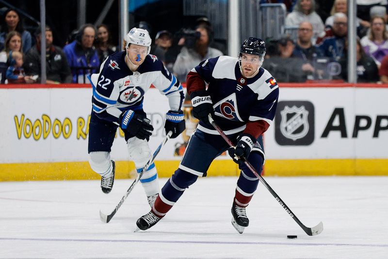 Apr 13, 2024; Denver, Colorado, USA; Colorado Avalanche defenseman Devon Toews (7) controls the puck ahead of Winnipeg Jets center Mason Appleton (22) in the second period at Ball Arena. Mandatory Credit: Isaiah J. Downing-USA TODAY Sports