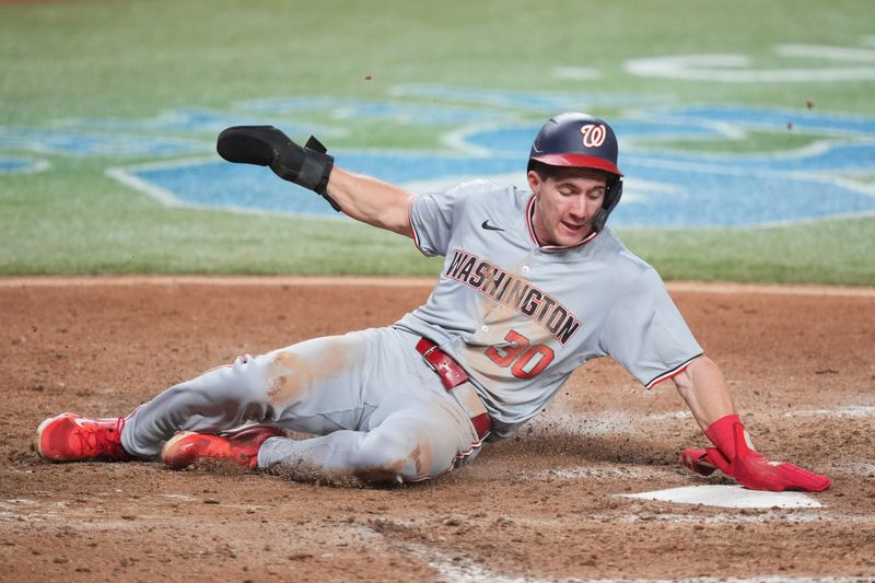 Sep 3, 2024; Miami, Florida, USA;  Washington Nationals center fielder Jacob Young (30) slides safely into home plate against the Miami Marlins in the ninth inning at loanDepot Park. Mandatory Credit: Jim Rassol-Imagn Images.