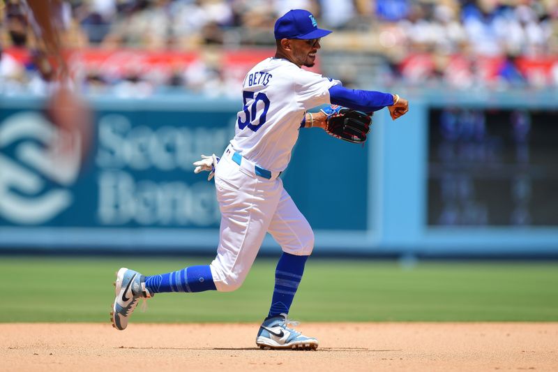 Jun 16, 2024; Los Angeles, California, USA; Los Angeles Dodgers shortstop Mookie Betts (50) throws to first for the out against Kansas City Royals third baseman Maikel Garcia (11) during the sixth inning at Dodger Stadium. Mandatory Credit: Gary A. Vasquez-USA TODAY Sports