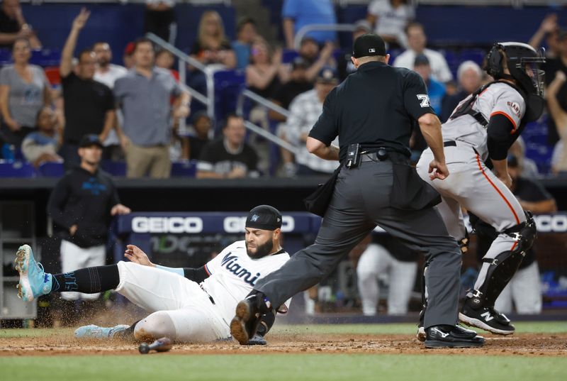 Apr 16, 2024; Miami, Florida, USA;  Miami Marlins third baseman Emmanuel Rivera (15) slides safely into home plate against San Francisco Giants catcher Tom Murphy (19) in the sixth inning at loanDepot Park. Mandatory Credit: Rhona Wise-USA TODAY Sports