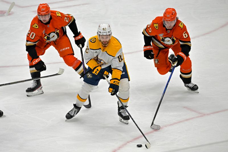 Jan 25, 2025; Anaheim, California, USA; Nashville Predators center Tommy Novak (82) controls the puck away from Anaheim Ducks right wing Brett Leason (20) and defenseman Jacob Trouba (65) in the second period at Honda Center. Mandatory Credit: Jayne Kamin-Oncea-Imagn Images