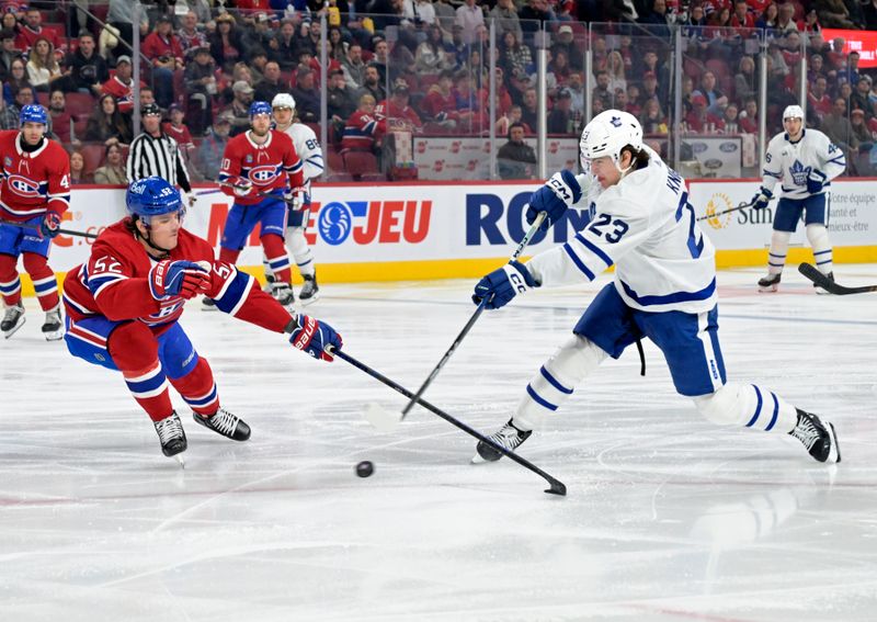 Apr 6, 2024; Montreal, Quebec, CAN; Toronto Maple Leafs forward Matthew Knies (23) takes as hot on net and Montreal Canadiens defenseman Justin Barron (52) defends during the first period at the Bell Centre. Mandatory Credit: Eric Bolte-USA TODAY Sports