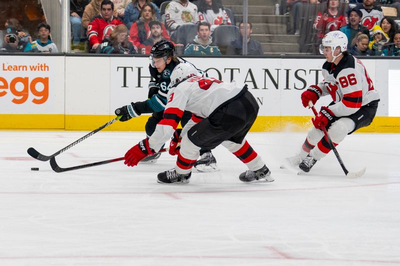 Feb 27, 2024; San Jose, California, USA;  New Jersey Devils defenseman Luke Hughes (43) defends against the fast break by San Jose Sharks center Mikael Granlund (64) during the second period at SAP Center at San Jose. Mandatory Credit: Neville E. Guard-USA TODAY Sports