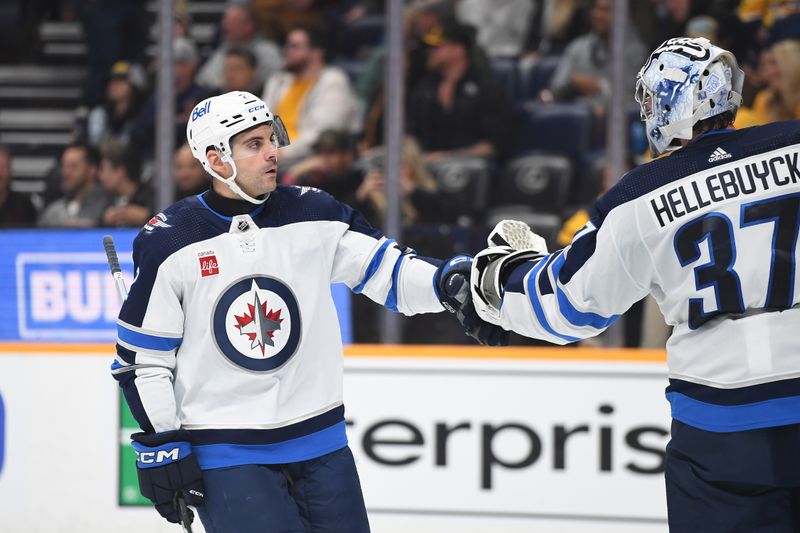 Apr 9, 2024; Nashville, Tennessee, USA; Winnipeg Jets defenseman Dylan DeMelo (2) celebrates with goaltender Connor Hellebuyck (37) after a goal during the first period against the Nashville Predators at Bridgestone Arena. Mandatory Credit: Christopher Hanewinckel-USA TODAY Sports