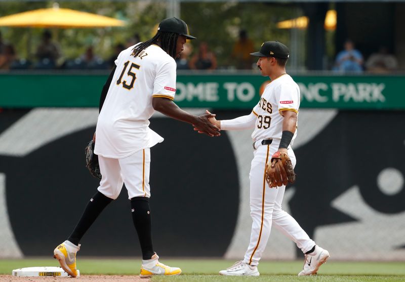 Jul 24, 2024; Pittsburgh, Pennsylvania, USA;  Pittsburgh Pirates shortstop Oneil Cruz (15) and second baseman Nick Gonzales (39) celebrate after defeating the St. Louis Cardinals at PNC Park. Pittsburgh won 5-0. Mandatory Credit: Charles LeClaire-USA TODAY Sports