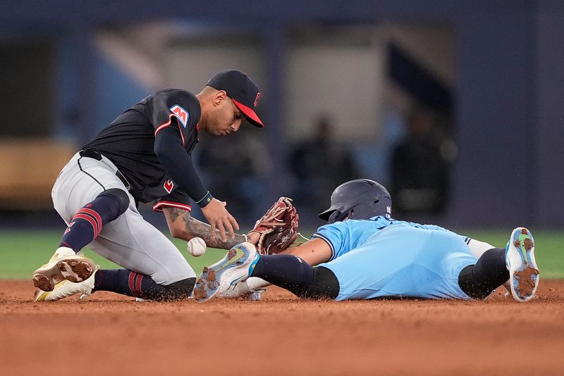 May 4, 2025; Toronto, Ontario, CAN; Toronto Blue Jays shortstop Bo Bichette (11) steals second base as Cleveland Guardians shortstop Brayan Rocchio (4) bobbles the ball during the ninth inning at Rogers Centre. Mandatory Credit: John E. Sokolowski-Imagn Images