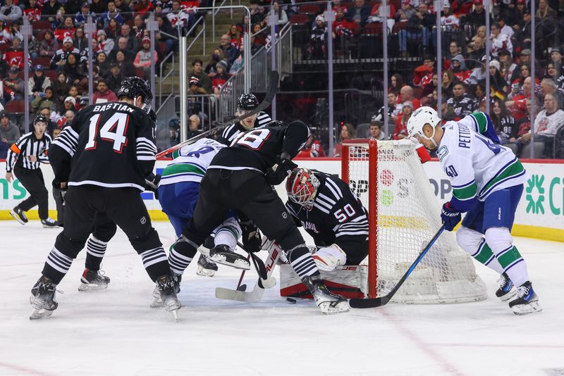 Jan 6, 2024; Newark, New Jersey, USA; New Jersey Devils goaltender Nico Daws (50) makes a save against the Vancouver Canucks during the first period at Prudential Center. Mandatory Credit: Ed Mulholland-USA TODAY Sports