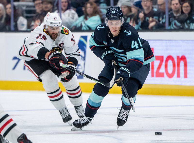 Nov 14, 2024; Seattle, Washington, USA;  Seattle Kraken defenseman Ryker Evans (41) skates against Chicago Blackhawks forward Nick Foligno (17) during the first period at Climate Pledge Arena. Mandatory Credit: Stephen Brashear-Imagn Images