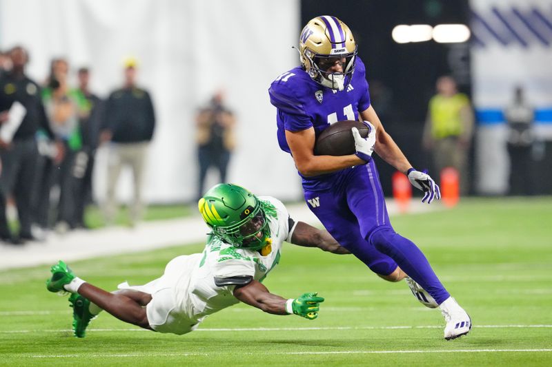 Dec 1, 2023; Las Vegas, NV, USA; Washington Huskies wide receiver Jalen McMillan (11) evades the tackle of Oregon Ducks defensive back Khyree Jackson (5) during the second quarter at Allegiant Stadium. Mandatory Credit: Stephen R. Sylvanie-USA TODAY Sports