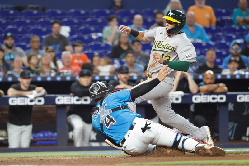 May 4, 2025; Miami, Florida, USA; Oakland Athletics third baseman Gio Urshela (13) is tagged out at the plate by Miami Marlins catcher Nick Fortes (4) during the second inning at loanDepot Park. Mandatory Credit: Rhona Wise-Imagn Images