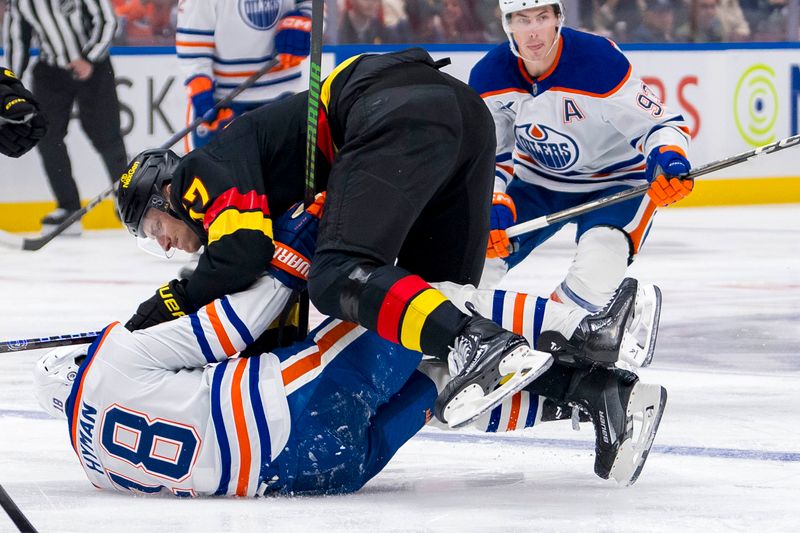 Nov 9, 2024; Vancouver, British Columbia, CAN; Vancouver Canucks defenseman Tyler Myers (57) checks Edmonton Oilers forward Zach Hyman (18) during the first period at Rogers Arena. Mandatory Credit: Bob Frid-Imagn Images