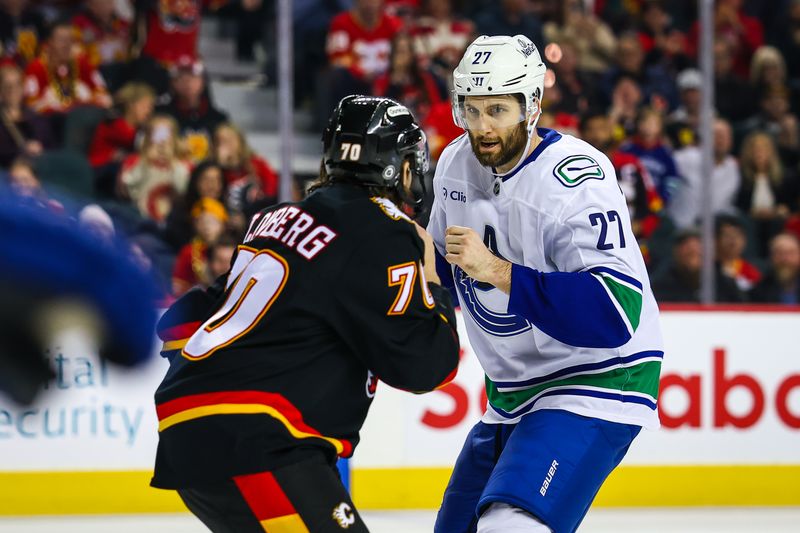 Dec 31, 2024; Calgary, Alberta, CAN; Vancouver Canucks defenseman Derek Forbort (27) and Calgary Flames left wing Ryan Lomberg (70) fights during the second period at Scotiabank Saddledome. Mandatory Credit: Sergei Belski-Imagn Images