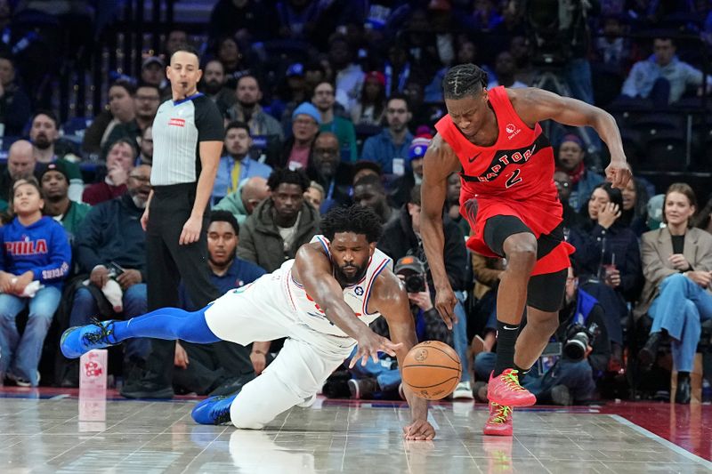 PHILADELPHIA, PENNSYLVANIA - FEBRUARY 11: Joel Embiid #21 of the Philadelphia 76ers dives for the ball against Jonathan Mogbo #2 of the Toronto Raptors in the second half at the Wells Fargo Center on February 11, 2025 in Philadelphia, Pennsylvania. The Raptors defeated the 76ers 106-103. NOTE TO USER: User expressly acknowledges and agrees that, by downloading and/or using this photograph, user is consenting to the terms and conditions of the Getty Images License Agreement. (Photo by Mitchell Leff/Getty Images)