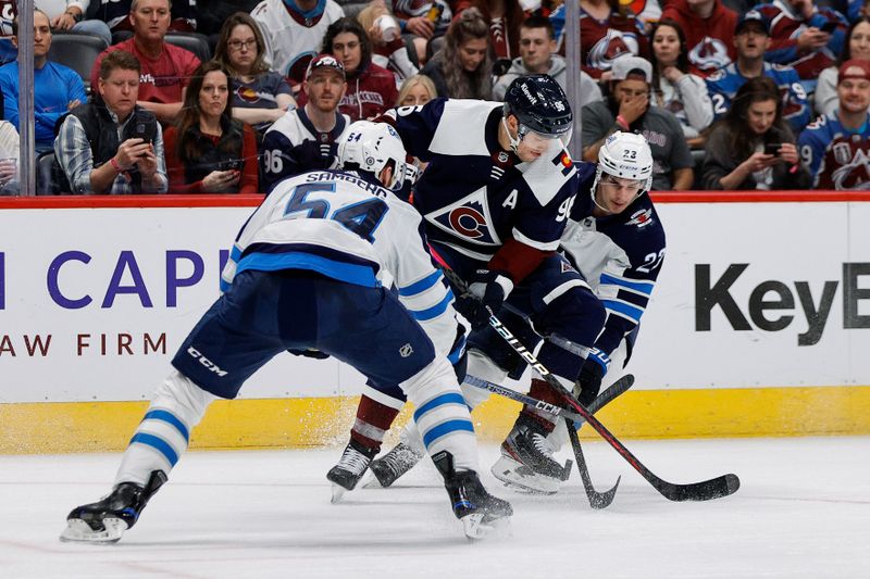 Apr 13, 2024; Denver, Colorado, USA; Colorado Avalanche right wing Mikko Rantanen (96) loses control of the puck against Winnipeg Jets defenseman Dylan Samberg (54) and center Sean Monahan (23) in the second period at Ball Arena. Mandatory Credit: Isaiah J. Downing-USA TODAY Sports