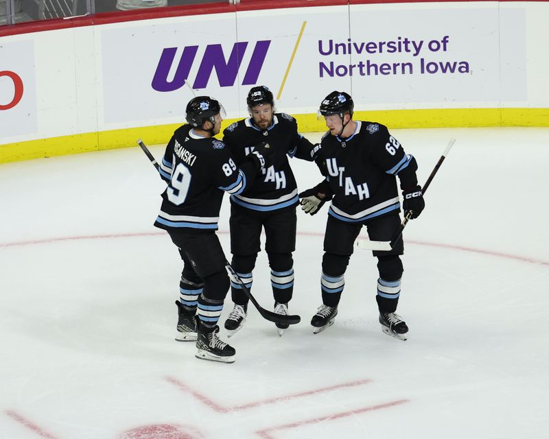 Sep 22, 2024; Des Moines, Iowa, USA;  Utah Hockey Club forward Michael Carcone (53) celebrates with Utah Hockey Club forward Austin Poganski (89)] and Utah Hockey Club forward Ben McCartney (62) after scoring the first goal in franchise history against the St. Louis Blues at Wells Fargo Arena. Mandatory Credit: Reese Strickland-Imagn Images

