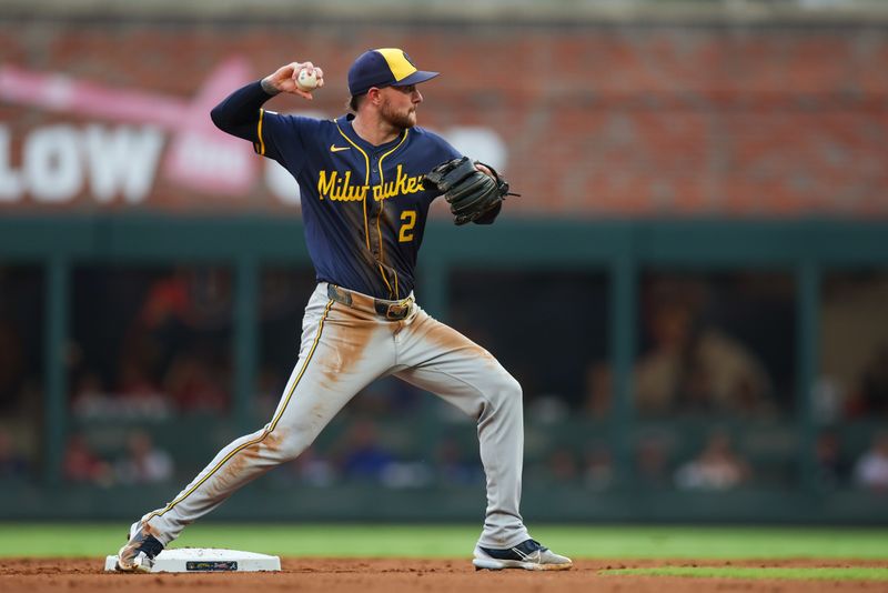 Aug 6, 2024; Atlanta, Georgia, USA; Milwaukee Brewers second baseman Brice Turang (2) turns a double play against the Atlanta Braves in the first inning at Truist Park. Mandatory Credit: Brett Davis-USA TODAY Sports