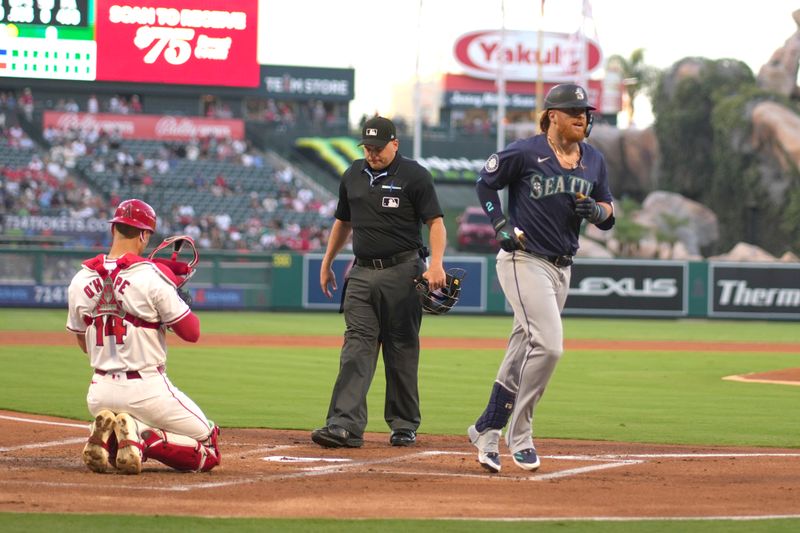 Aug 31, 2024; Anaheim, California, USA; Seattle Mariners first baseman Justin Turner (2) crosses home plate after hitting a home run in the second inning as Los Angeles Angels catcher Logan O'Hoppe (14) watches at Angel Stadium. Mandatory Credit: Kirby Lee-USA TODAY Sports