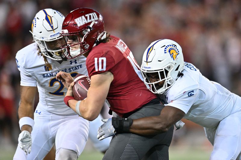 Sep 20, 2024; Pullman, Washington, USA; Washington State Cougars quarterback John Mateer (10) is tackled by San Jose State Spartans linebacker Jordan Cobbs (8) in the second at Gesa Field at Martin Stadium. Washington State Cougars won 54-52 in double overtime. Mandatory Credit: James Snook-Imagn Images