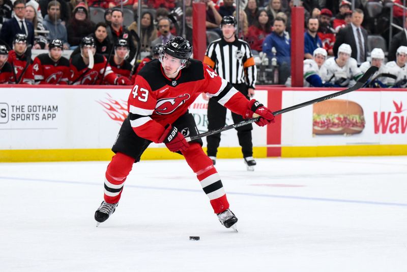Dec 14, 2025; Newark, New Jersey, USA; New Jersey Devils defenseman Luke Hughes (43) takes a slap shot against the Vancouver Canucks during the second period at Prudential Center. Mandatory Credit: John Jones-Imagn Images