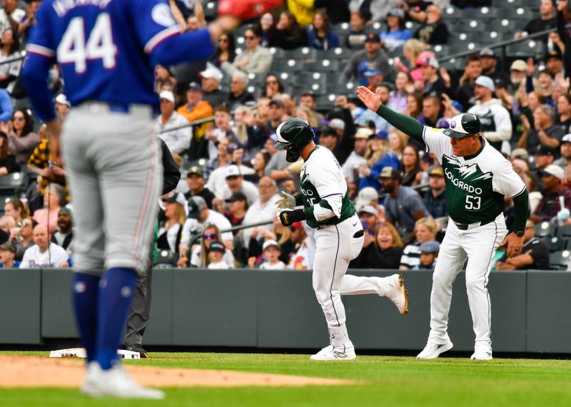 May 11, 2024; Denver, Colorado, USA; Colorado Rockies outfielder Hunter Goodman (15) celebrates with first base coach Ronnie Gideon (53) after hitting a home run against the Texas Rangers in the third inning at Coors Field. Mandatory Credit: John Leyba-USA TODAY Sports