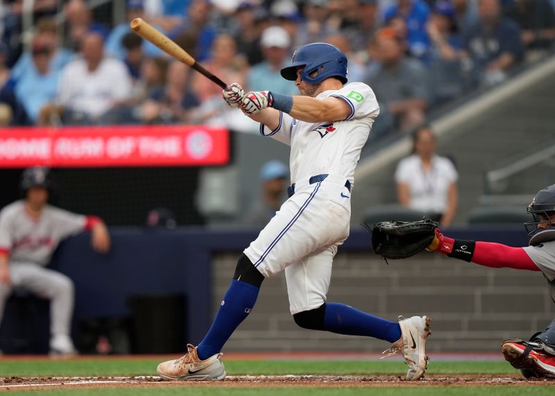 Jun 18, 2024; Toronto, Ontario, CAN; Toronto Blue Jays third baseman Ernie Clement (28) hits a two run double against the Boston Red Sox during the second inning at Rogers Centre. Mandatory Credit: John E. Sokolowski-USA TODAY Sports