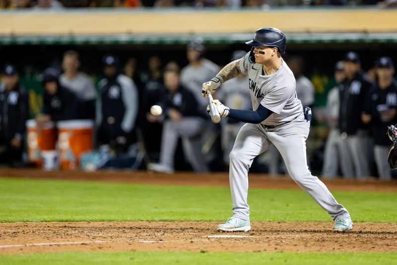 Sep 20, 2024; Oakland, California, USA; New York Yankees outfielder Alex Verdugo (24) bunts during the tenth inning to advance the runner against the Oakland Athletics at Oakland-Alameda County Coliseum. Mandatory Credit: Bob Kupbens-Imagn Images