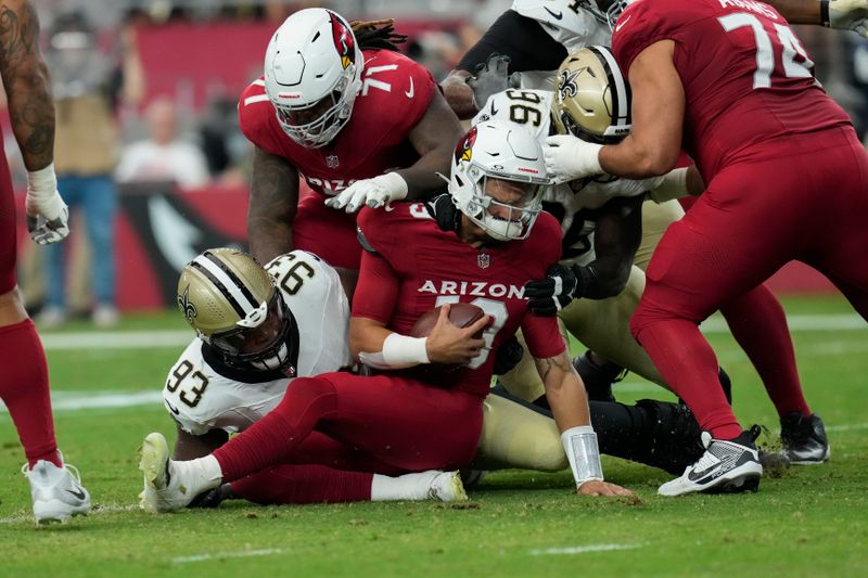 Arizona Cardinals quarterback Desmond Ridder is sacked by New Orleans Saints defensive tackle Nathan Shepherd (93) and defensive end Carl Granderson (96) in the first half of a preseason NFL football game, Saturday, Aug. 10, 2024, in Glendale, Ariz. (AP Photo/Ross D. Franklin)