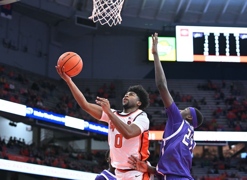 Dec 21, 2023; Syracuse, New York, USA; Syracuse Orange guard Kyle Cuffe Jr. (0) goes for a lay up with Niagara Purple Eagles forward Aime Rutayisire (24) defending in the second half at the JMA Wireless Dome. Mandatory Credit: Mark Konezny-USA TODAY Sports