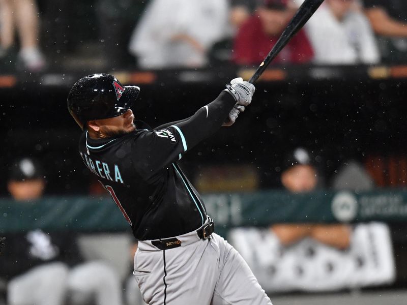 Jun 24, 2025; Chicago, Illinois, USA; Arizona Diamondbacks catcher Jose Herrera (11) hits a sacrifice RBI fly ball during the seventh inning against the Chicago White Sox at Rate Field. Mandatory Credit: Patrick Gorski-Imagn Images