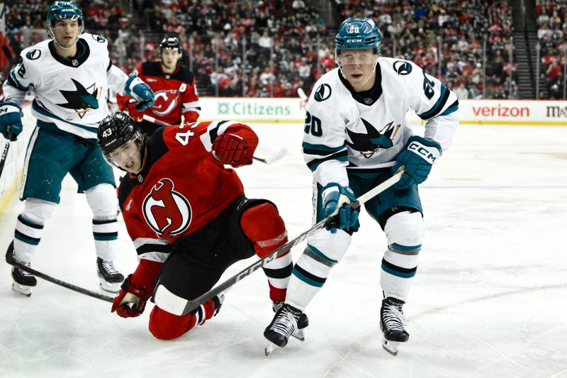 Nov 10, 2024; Newark, New Jersey, USA; New Jersey Devils defenseman Luke Hughes (43) and San Jose Sharks left wing Fabian Zetterlund (20) compete for the puck during the third period at Prudential Center. Mandatory Credit: John Jones-Imagn Images