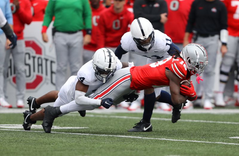 Oct 21, 2023; Columbus, Ohio, USA; Penn State Nittany Lions cornerback Kalen King (4) and linebacker Abdul Carter (11) tackle Ohio State Buckeyes wide receiver Marvin Harrison Jr. (18) during the third quarter at Ohio Stadium. Mandatory Credit: Joseph Maiorana-USA TODAY Sports