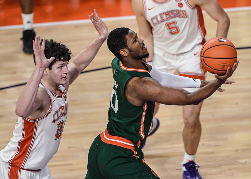 Feb 4, 2023; Clemson, South Carolina, USA; Miami forward AJ Casey (0) shoots near Clemson sophomore forward PJ Hall (24) during the first half at Littlejohn Coliseum in Clemson, S.C. Saturday, Feb. 4, 2023.  Mandatory Credit: Ken Ruinard-USA TODAY Sports