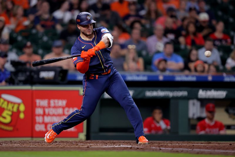 May 20, 2024; Houston, Texas, USA; Houston Astros catcher Yainer Diaz (21) hits an RBI single against the Los Angeles Angels during the second inning at Minute Maid Park. Mandatory Credit: Erik Williams-USA TODAY Sports