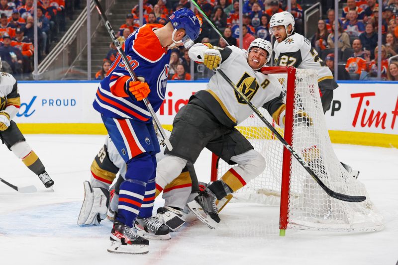 Apr 10, 2024; Edmonton, Alberta, CAN; Edmonton Oilers forward Corey Perry (90) knocks Vegas Golden Knights defensemen Brayden McNabb (3) over goaltender Adin Hill (33) and into the net during the third period at Rogers Place. Mandatory Credit: Perry Nelson-USA TODAY Sports