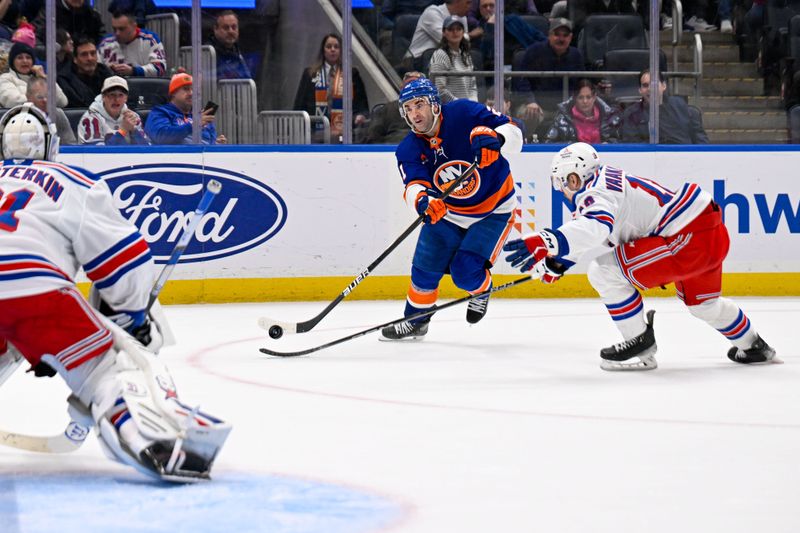 Feb 25, 2025; Elmont, New York, USA;  New York Islanders center Kyle Palmieri (21) shoots against New York Rangers defenseman Urho Vaakanainen (18) during the second period at UBS Arena. Mandatory Credit: Dennis Schneidler-Imagn Images