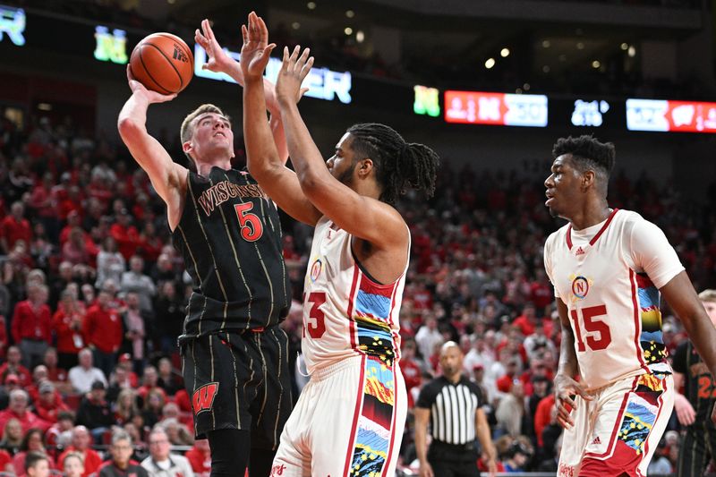 Feb 11, 2023; Lincoln, Nebraska, USA;  Wisconsin Badgers forward Tyler Wahl (5) shoots over Nebraska Cornhuskers forward Derrick Walker (13) and forward Blaise Keita (15) in the second half at Pinnacle Bank Arena. Mandatory Credit: Steven Branscombe-USA TODAY Sports