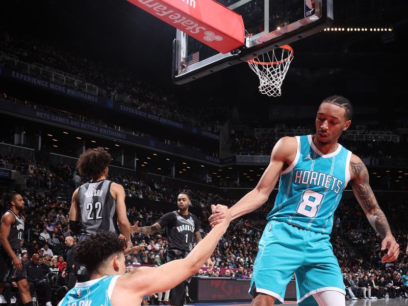 BROOKLYN, NY - FEBRUARY 10: KJ Simpson #25 is helped up by Nick Smith Jr. #8 of the Charlotte Hornets during the game against the Brooklyn Netson February 10, 2025 at Barclays Center in Brooklyn, New York. NOTE TO USER: User expressly acknowledges and agrees that, by downloading and or using this Photograph, user is consenting to the terms and conditions of the Getty Images License Agreement. Mandatory Copyright Notice: Copyright 2025 NBAE (Photo by Nathaniel S. Butler/NBAE via Getty Images)