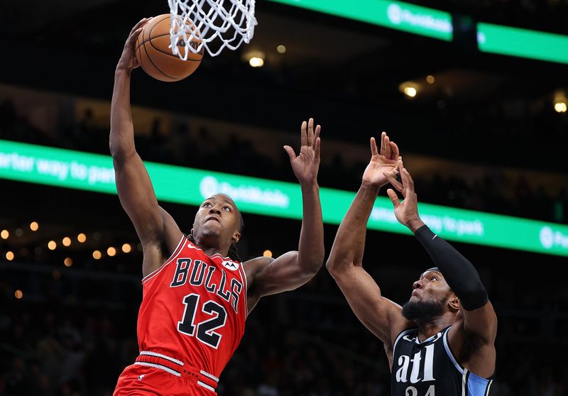 ATLANTA, GEORGIA - FEBRUARY 12:  Ayo Dosunmu #12 of the Chicago Bulls dunks against Bruno Fernando #24 of the Atlanta Hawks during the fourth quarter at State Farm Arena on February 12, 2024 in Atlanta, Georgia.  NOTE TO USER: User expressly acknowledges and agrees that, by downloading and/or using this photograph, user is consenting to the terms and conditions of the Getty Images License Agreement.  (Photo by Kevin C. Cox/Getty Images)